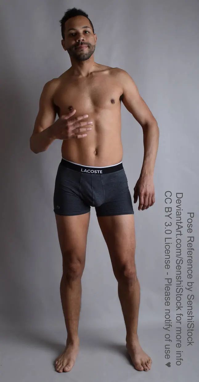 A Latino man standing, one arm bent up towards his chest