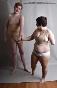A shorter white person leading a much taller white person by their hand.