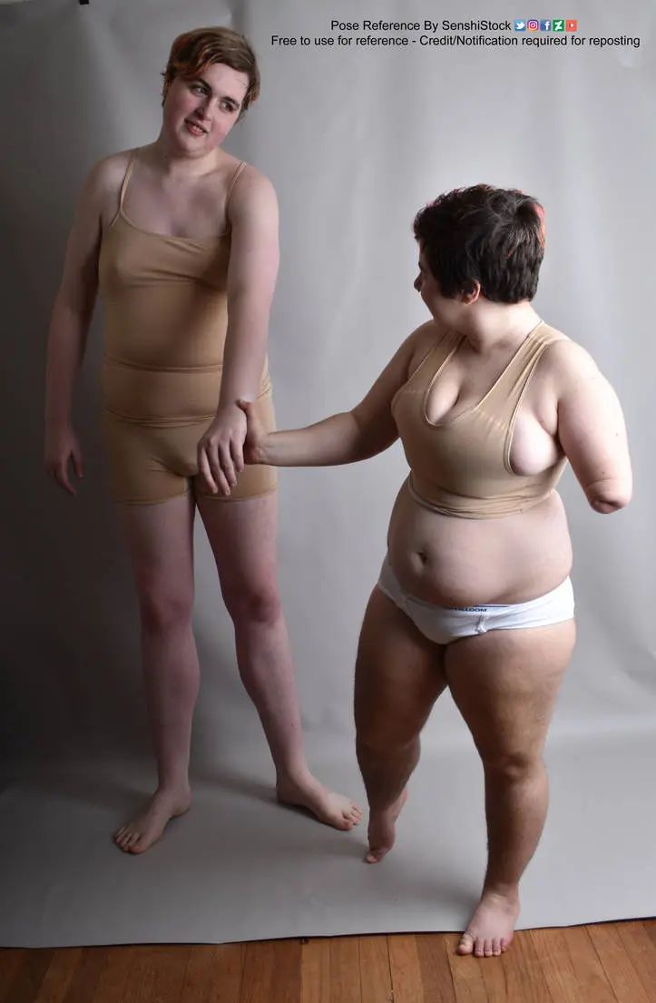A shorter white person leading a much taller white person by their hand.