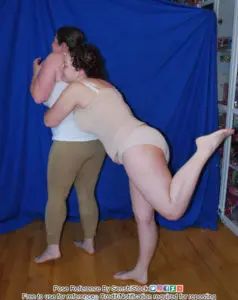 one pose reference model sneaks up behind another and grabs her around the waist, startling her
