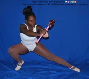 A Black woman standing and lunging, holding a Sailor Moon style wand out as if to attack.
