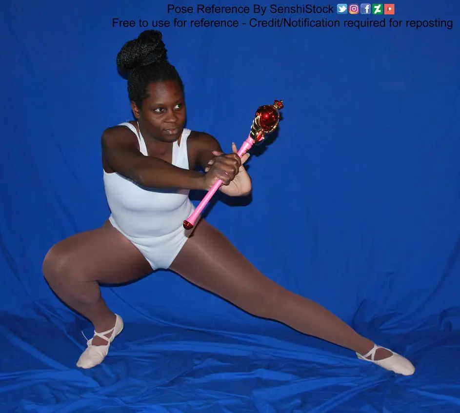 A Black woman standing and lunging, holding a Sailor Moon style wand out as if to attack.