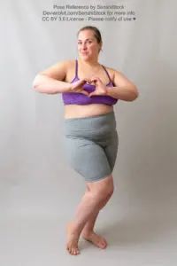 A fat white woman making a heart gesture in front of her chest and smiling