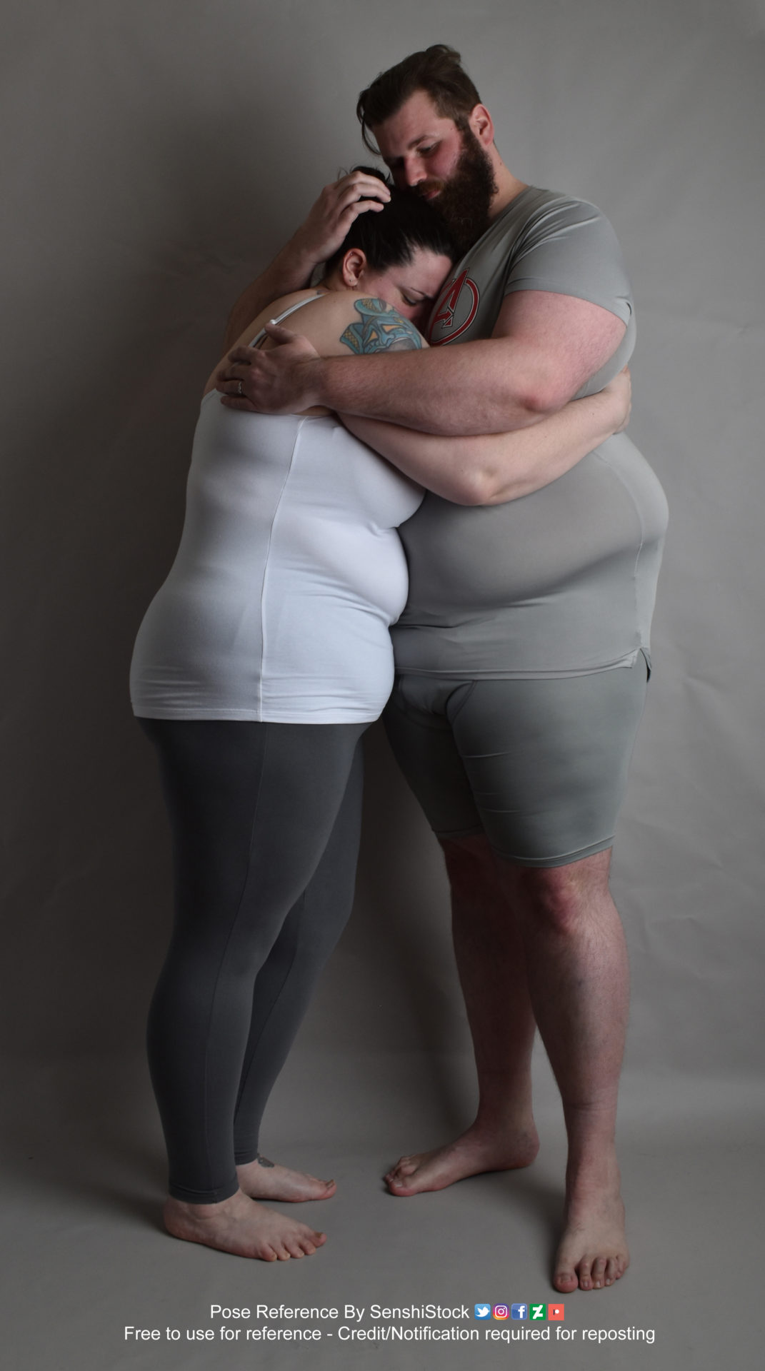 Two fat white models wearing skin tight clothing are wrapped in an embrace in each other's arms, tightly pressed up against each other. The shorter one is pressing their face into the taller one. The shot is in profile.