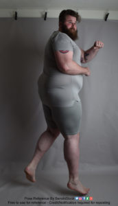 A fat white model wearing skin tight clothing is caught mid-air, his back mostly turned toward us in a 3/4 view, as he's looking back and holding up a fist.
