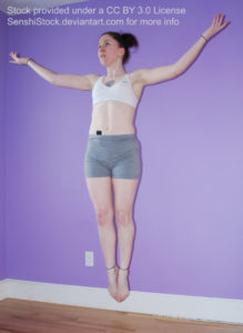 A white woman, rising up into the air, legs and feet together, arms outstretched.