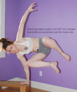 A white woman leaping over something, one arm on a bench, the other up in the air, both legs in the air.