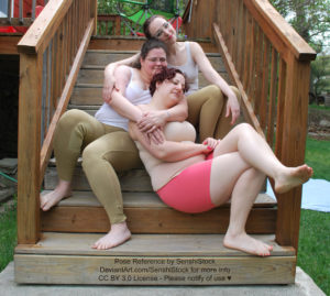 A group of various sized white women are cuddled together on a set of stairs, each relaxed and laying on top of each other.