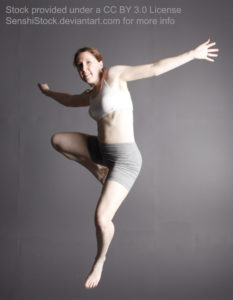 White woman jumping in the air, arms outstretched, wearing a white top and grey skin tight pants.