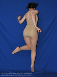 A white woman leaping/skipping, back to the camera, on a blue background.