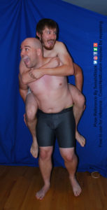 Two white men with boxers, one giving a piggy back ride to the other.