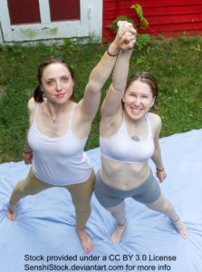 Two thin white women seen from a bird's eye view with them standing side by side, fingers interlaced together with their arms raised in celebration.