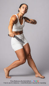 pose reference photo of a fit, Latina model in a partial lunge holding two hand blades