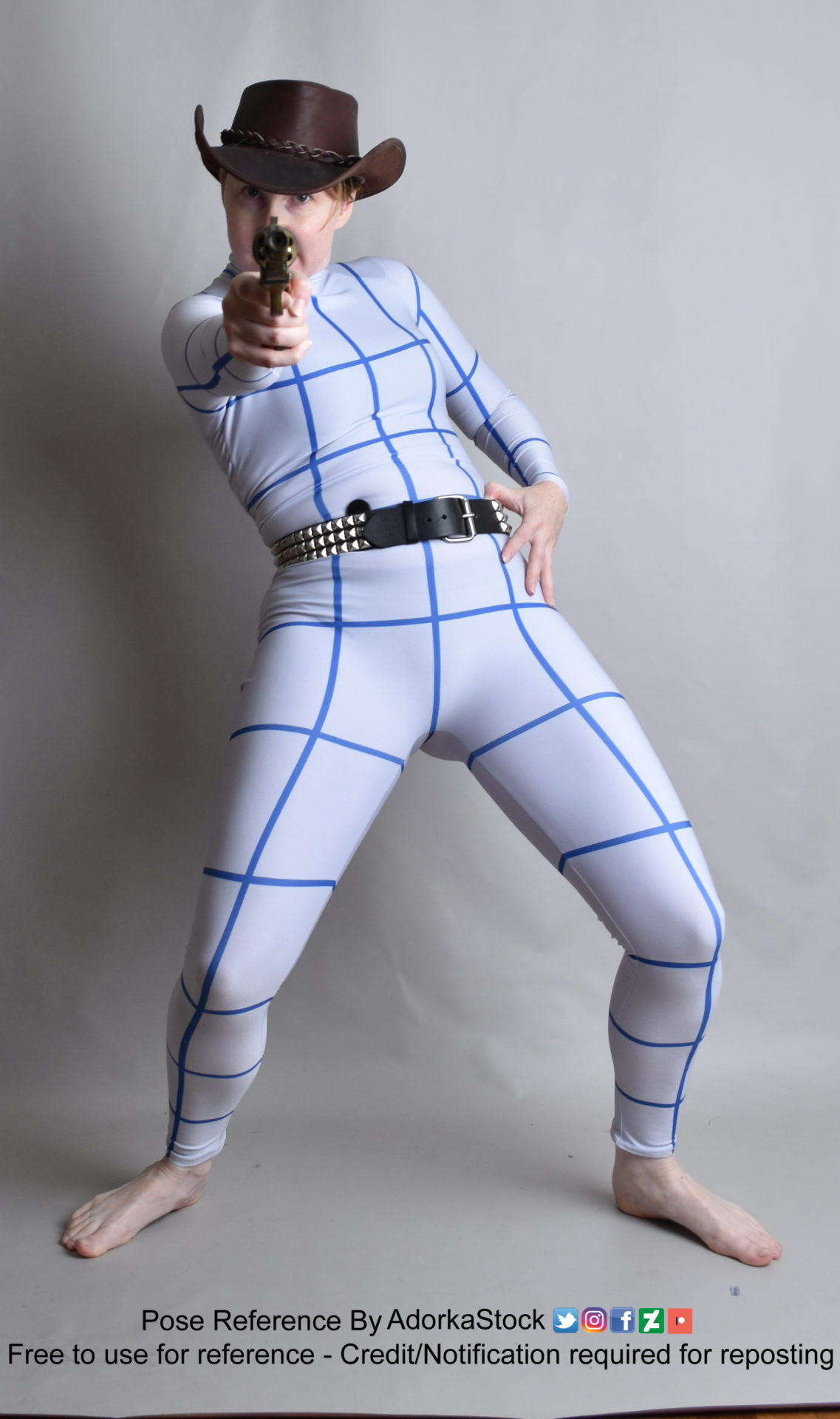 Pose reference photo of a thin, white, female model in a grid suit wearing a cowboy hat and holding a revolver aimed at the camera with her legs in a wide stance squat