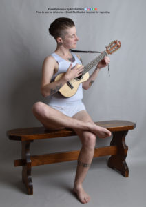 thin, white, nonbinary model sitting on a bench playing a ukulele