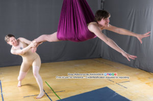 two pose reference models, one is suspended as if flying and the other is grabbing a foot while standing on the ground trying to prevent the flying model from getting away
