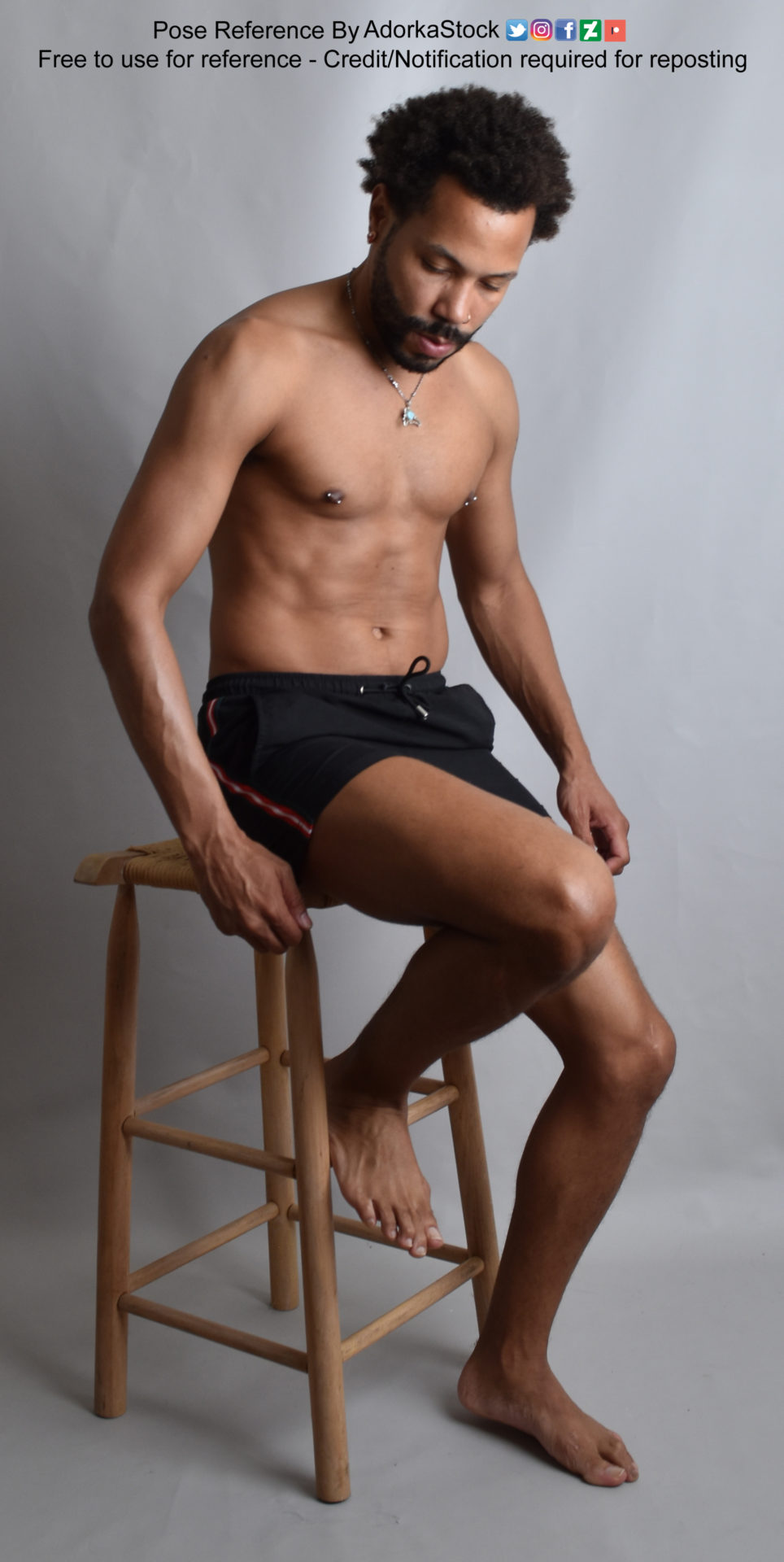 Thin Latino model taking a seat on a stool