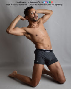 A Latino male model on his knees, leaning back with his hands behind his head