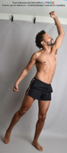 Thin, Latino, male pose reference reaching up with a fist over his head in profile, weight on one leg