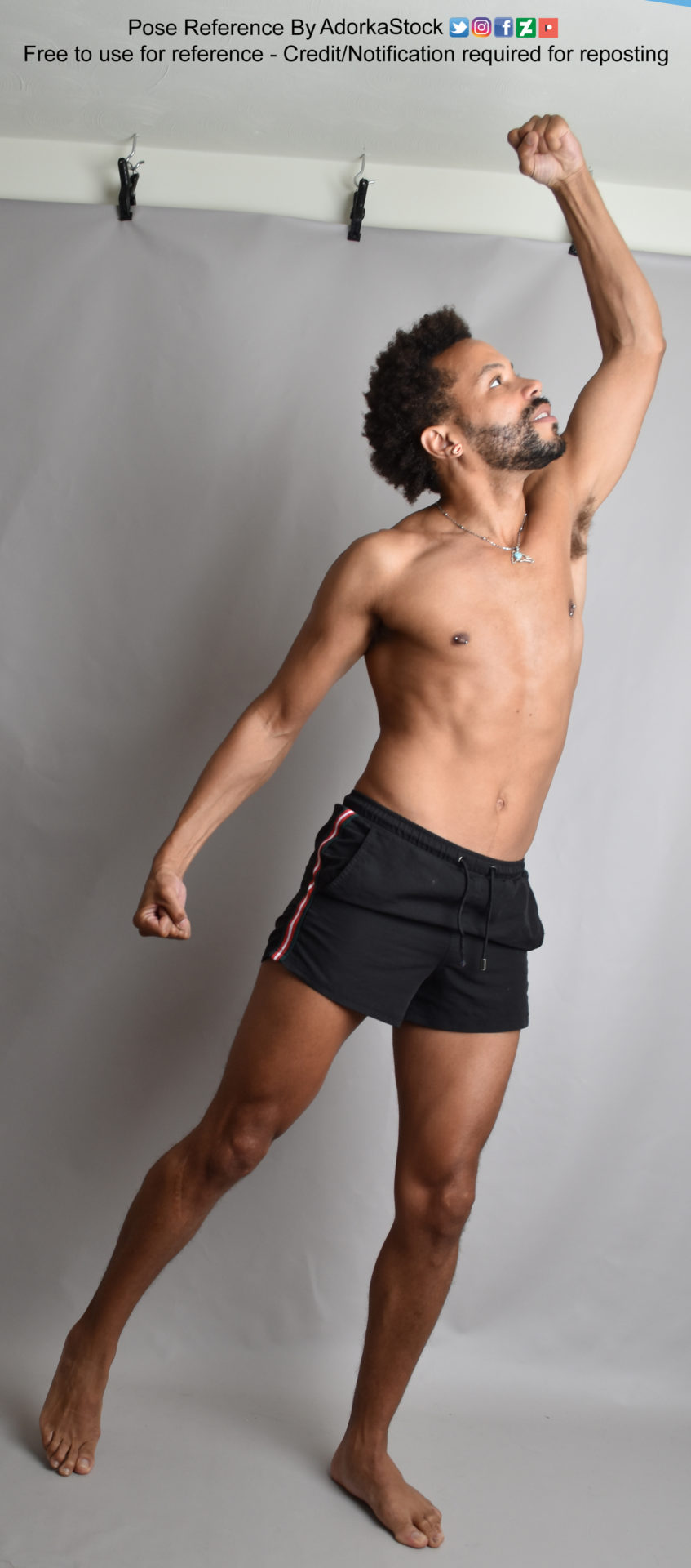 Thin, Latino, male pose reference reaching up with a fist over his head in profile, weight on one leg