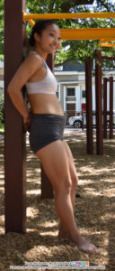 fit, Asian, female pose reference model leaning against the playground