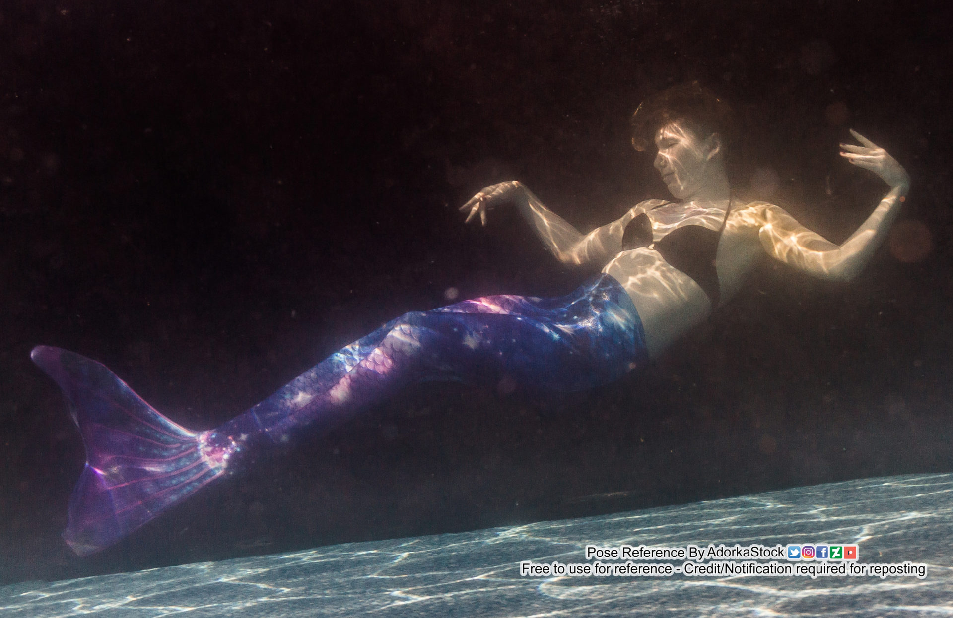 white female thin pose reference model underwater wearing a mermaid tail with open arm gesture