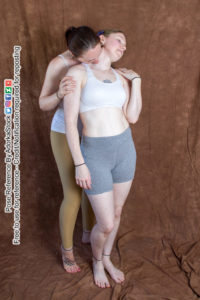 pose reference of two models, one is slightly behind the other grasping her by the shoulders and seductively biting her neck like a vampire