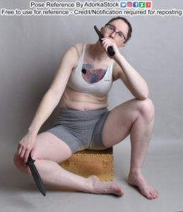 Fit, white, female pose reference model sitting casually on a box, holding two short blades, one low, the other close to the face