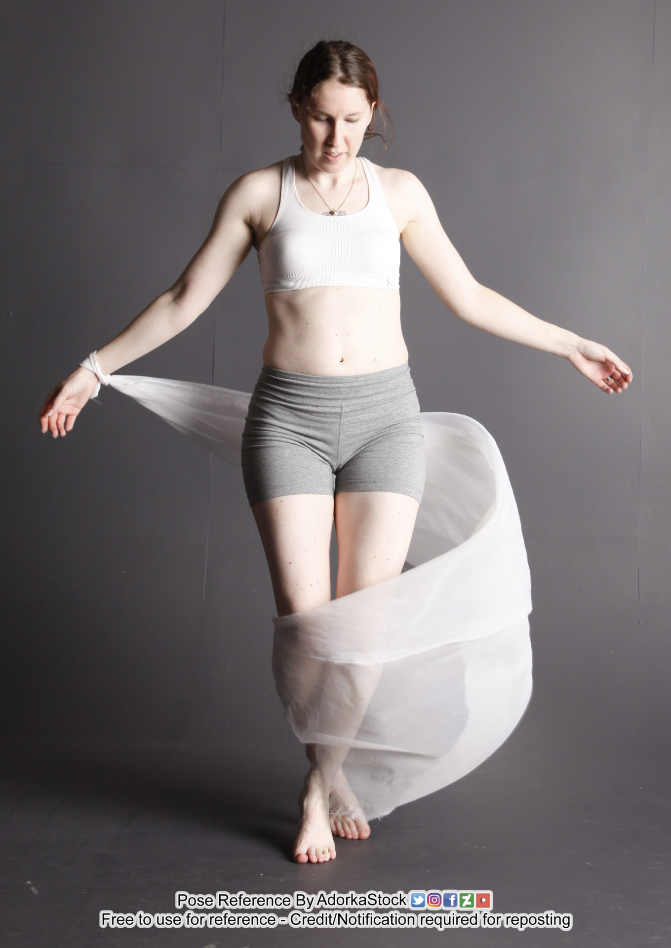 White, fit, female model with legs together and arms out, there's a loose white fabric wrapping from her wrist and down around her legs