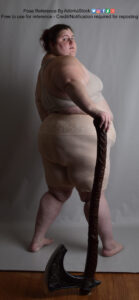 Model Lauren with her back to the camera, looking over her shoulder as she holds an axe in her left hand