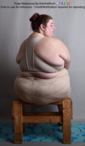 Model Lauren with her back facing the camera and sitting on a bench. She's looking over her right shoulder at the camera
