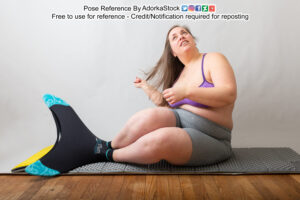 Chubby model Rowena smiling and looking up as she flips her hair over her shoulder. She's wearing a mermaid style flipper fin.