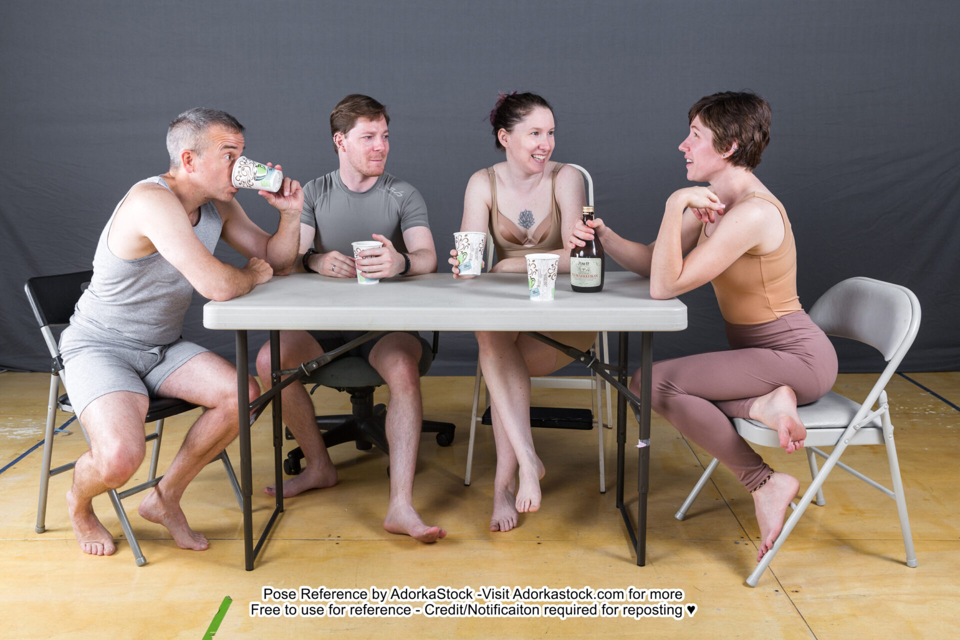 Four pose reference models sitting around a table with some cups having a casual chat, one is sipping.