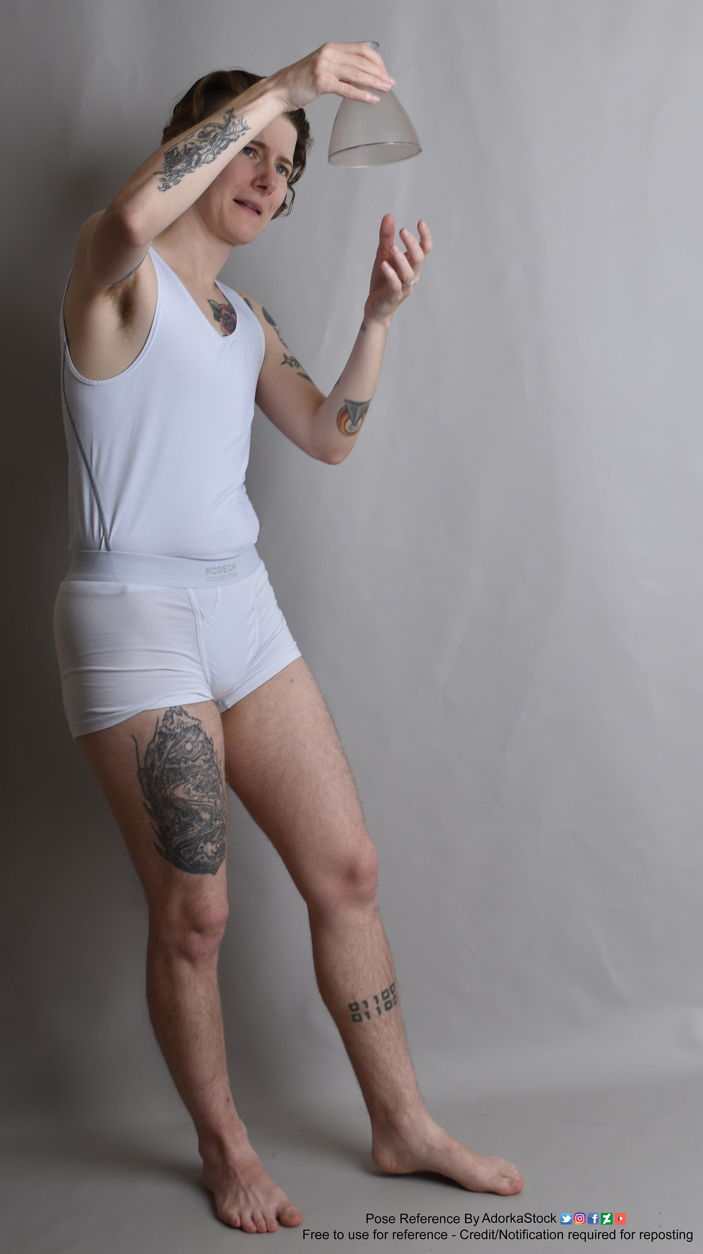 Thin, white, nonbinary pose reference model in standing pose with a science beaker held up in one hand the other slightly under it.