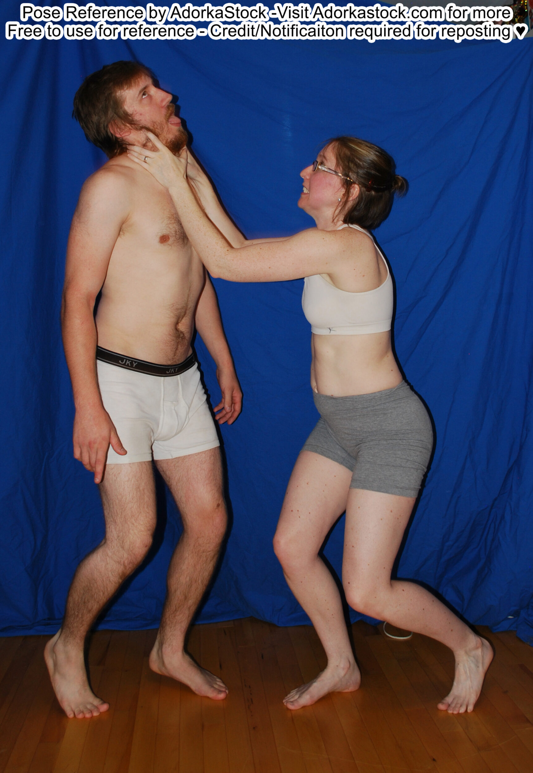 Thin, white, female pose reference model in standing profile pose with her hands around the neck of a taller, male model who looks like he's being choked.