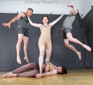 Group pose reference with a central model standing protectively over another model lying on the ground, the central model has her arms up flinging away would be attackers
