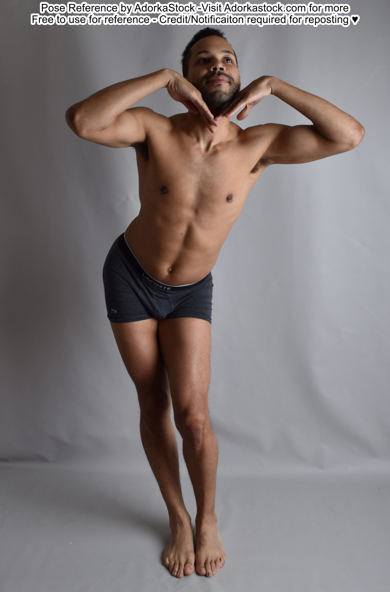 thin, Latino pose reference model in standing, playful pose with his hands under his chin and one hip popped out to the side