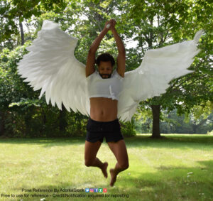 Thin, Latino, male pose reference model in jumping pose with arms and legs back, holding a sword.