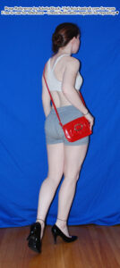 thin, white, female pose reference model in back facing, walking pose with high heels and a small cross body purse