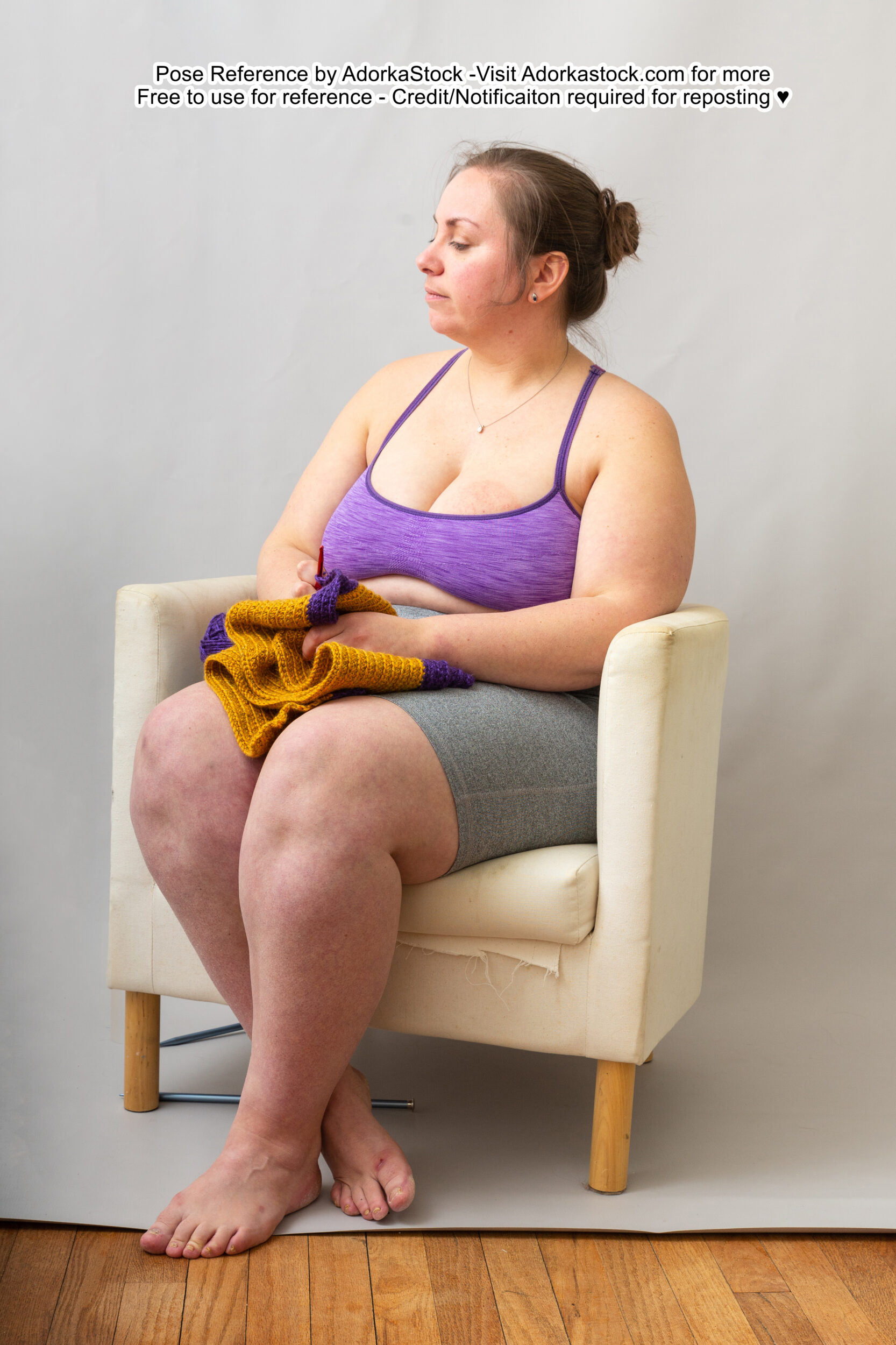 fat, white, female pose reference model in profile sitting pose with an unfinished knitting project in her lap