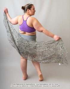 fat, white, female pose reference model in standing back facing pose with a long scarf held spread out, she is looking off to the side face in profile