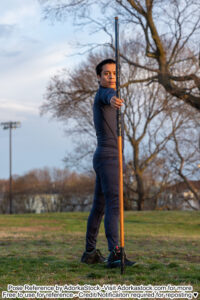 thin, Asian, male pose reference model in standing pose with large staff