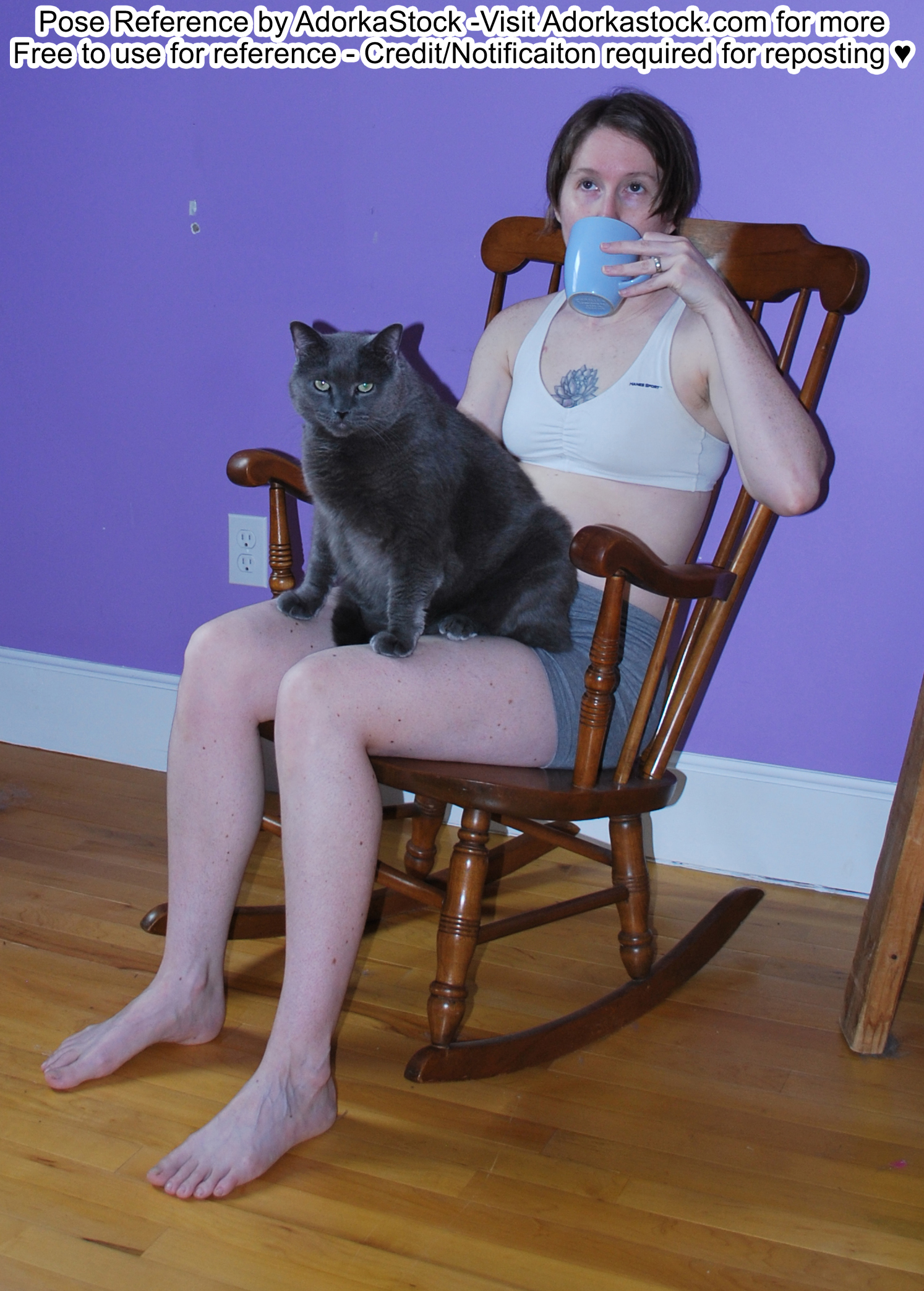 thin, white, female pose reference model in rocking chair pose with a large gray cat on her lap while she sips a mug