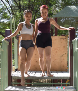 Two Asian, female pose reference models walking down steps together casually