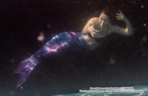 mermaid pose reference model underwater with clawlike hands reaching towards the camera