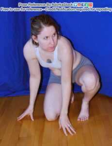 Thin, white, female model is crouching on the floor with one knee down, the other raised. She has both hands on the floor with fingertips touching and she's looking off to the right with some amount of tension.