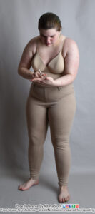 white nonbinary model holding a crayon like a cigarette and pointing to their other hand as if counting or telling a story
