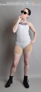 thin white female model standing in boots taking a drag on a cigarette with one hand on a hip