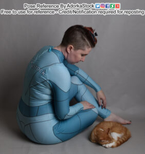 thin white female model in grid pose suit sitting facing away looking down at a curled up sleeping cat
