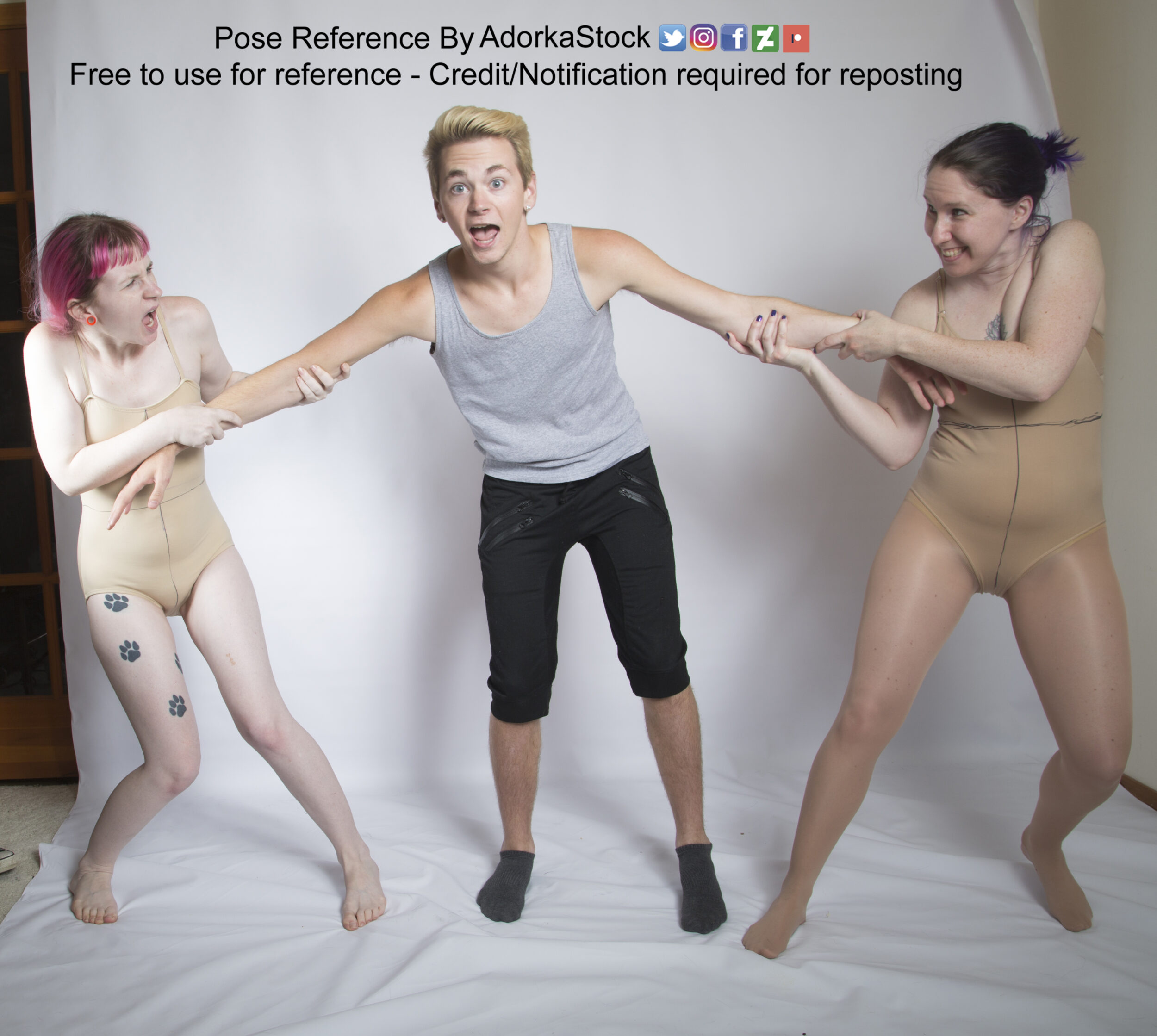 Two female models holding onto the arms of a male model in the middle as if using him in a tug of war